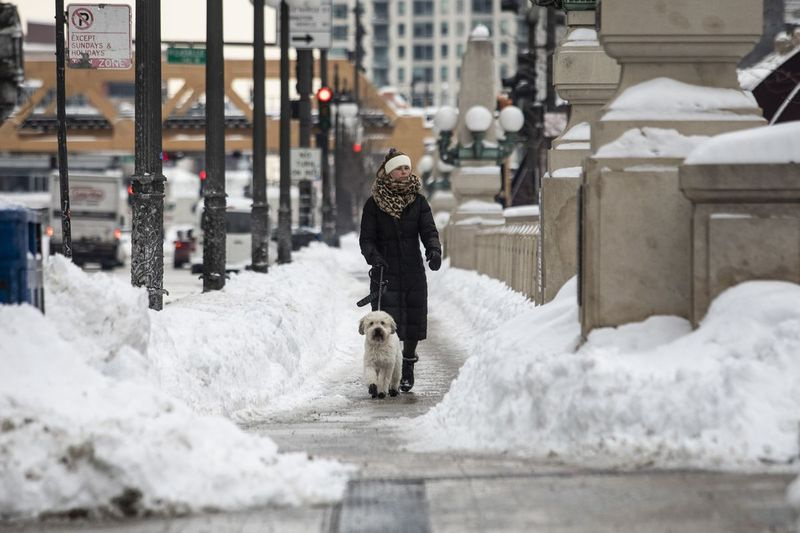 Žena venčí svého psa na West Wacker Drive poblíž North Clark Street v Loop, jeden den poté, co části Chicaga zachvátila největší zimní bouře ve městě v této sezóně, ve středu 17. února 2021.