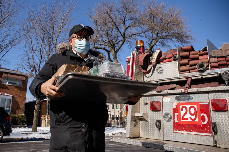 Omar Solis, ägare till restauranggruppen Nana, levererar mat till brandmän på torsdag vid motor 29 i Bridgeport. White Sox pitcher Liam Hendriks och hans fru Kristi donerade mat från lokala restauranger till Chicago Fire Department brandmän.