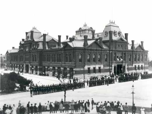 Pullman-Streikende außerhalb des Arcade-Gebäudes in Pullman, Chicago, im Jahr 1894. Die Illinois National Guard kann das Gebäude während des Pullman-Eisenbahn-Streiks bewachen.